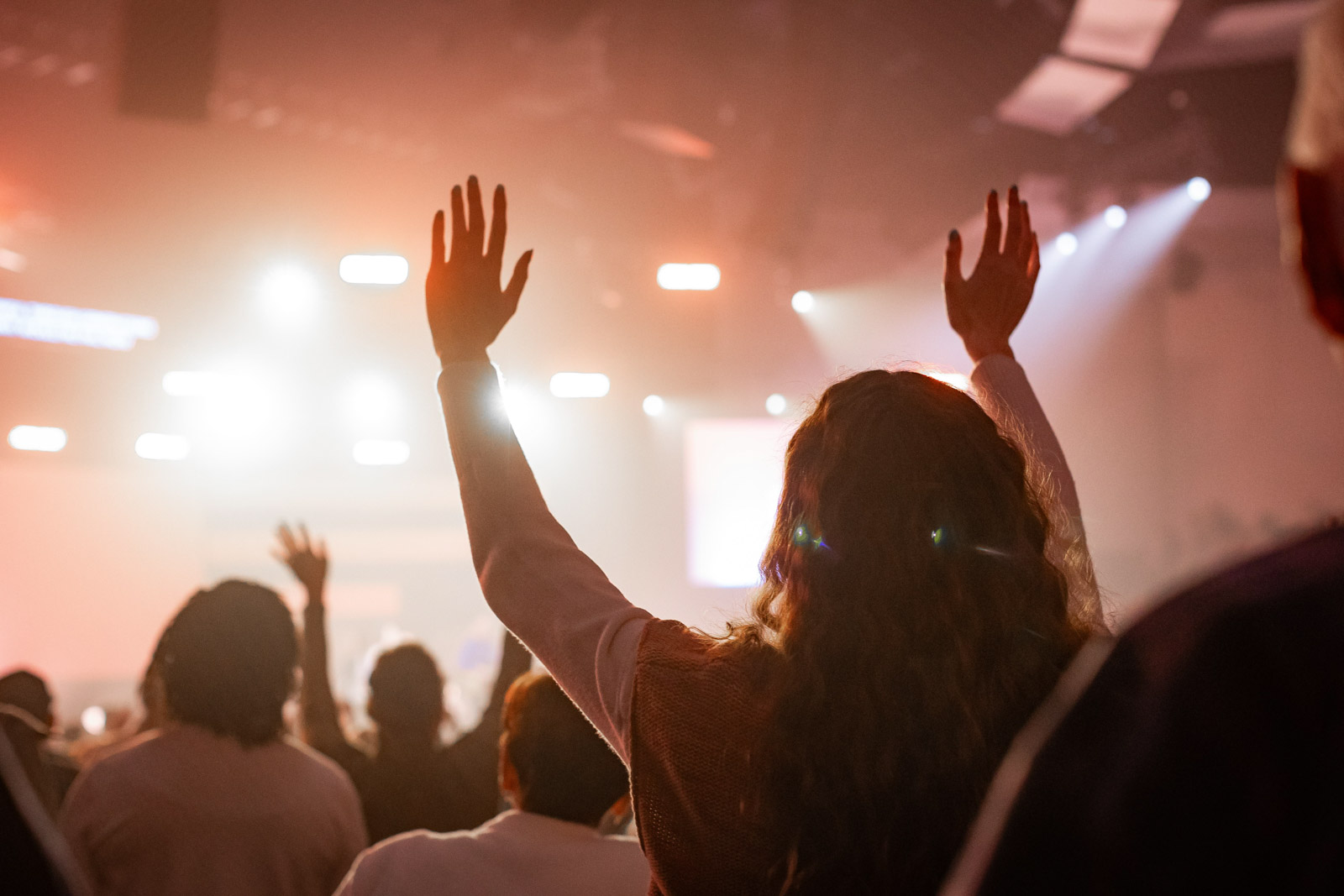 Women in a crowd with their hands up